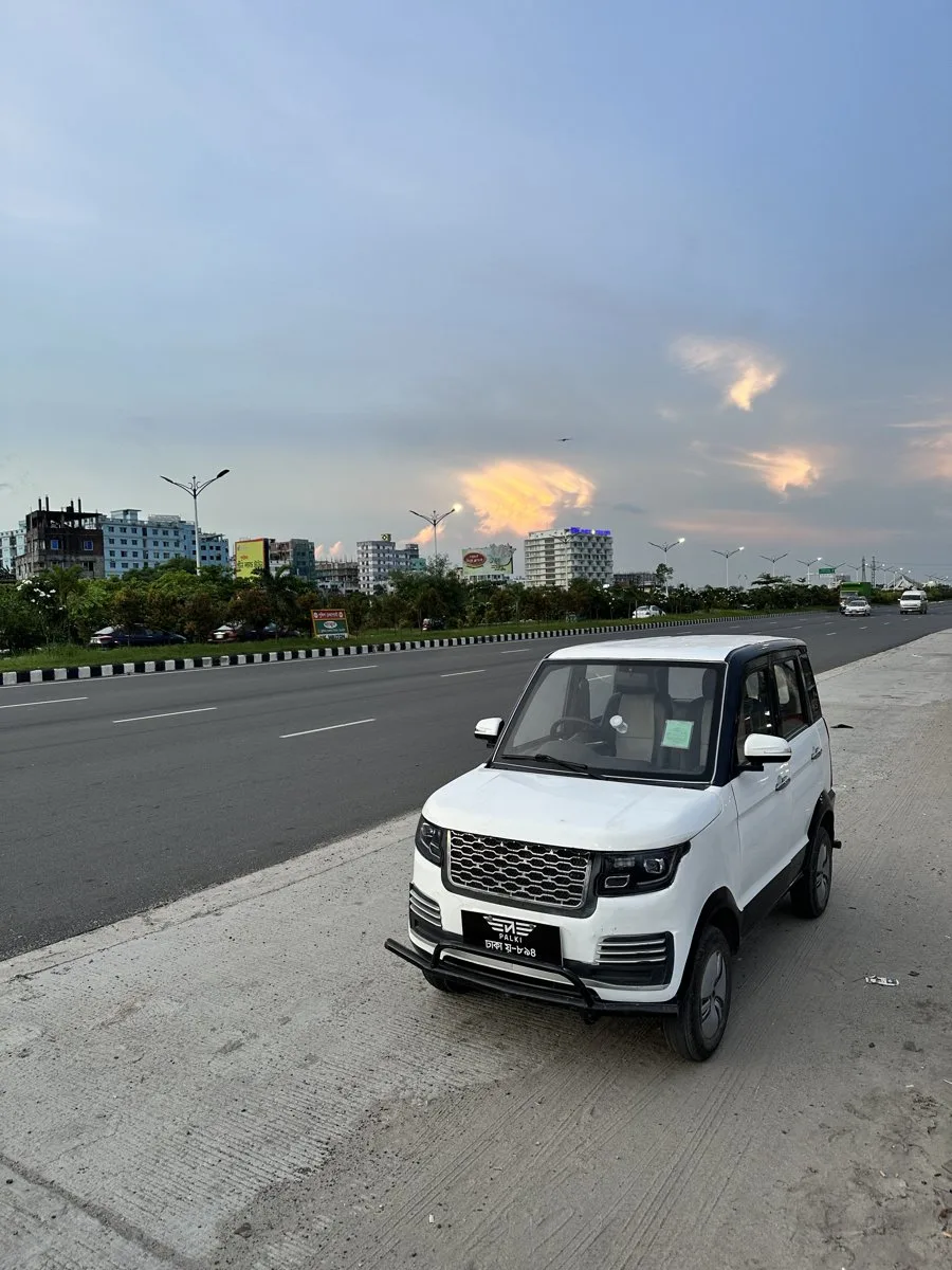 Cityboy V2 on highway at dusk, Dhaka skyline